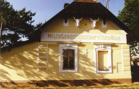 Ketzelsdorfer Milchkammer, © Christian Mock Ein gelbes Gebäude mit der Aufschrift 'Milchgenossenschaftsgebäude' und zwei Stierschädeln an der Fassade.