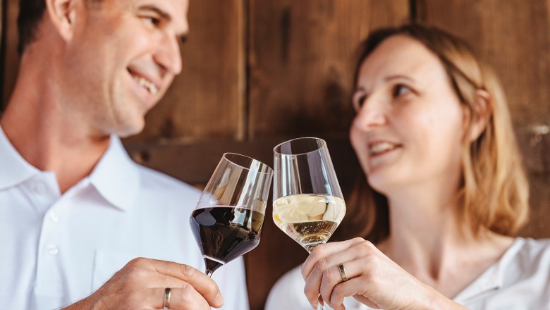 Bernhard & Tanja Scheiner, © Michael Reidinger Ein Mann und eine Frau stoßen mit Weingläsern an.