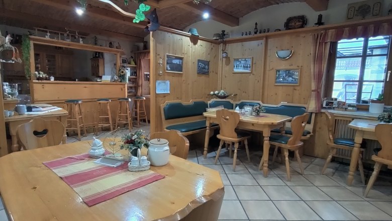 Frühstücksraum, © Arkadenhof Schneider Gemütlicher Frühstücksraum mit Holzmöbeln und Dekorationen.