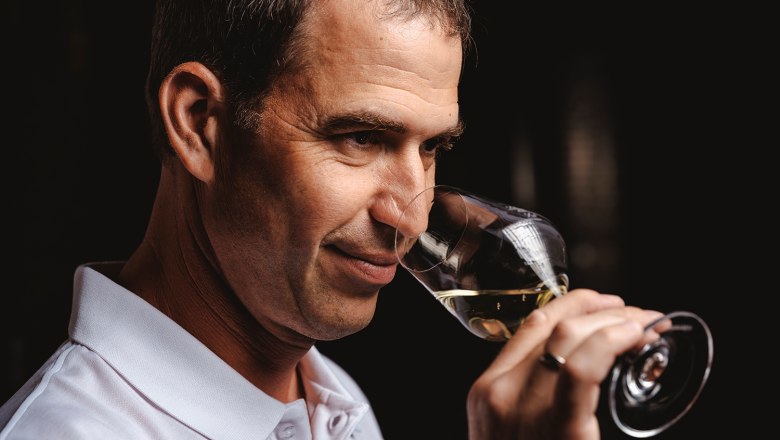 Bernhard Scheiner, © Michael Reidinger Person riecht an einem Glas Weißwein.