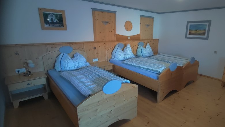 Ideal für Familien, © Arkadenhof Schneider Gemütliches Schlafzimmer mit zwei Einzelbetten aus Holz, Nachttisch und Kommode.