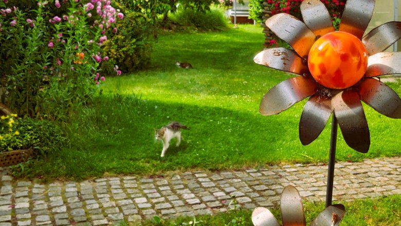 Garten, © Fam. Heinrich Ein Garten mit Blumen, einer Katze und Metallblumen.