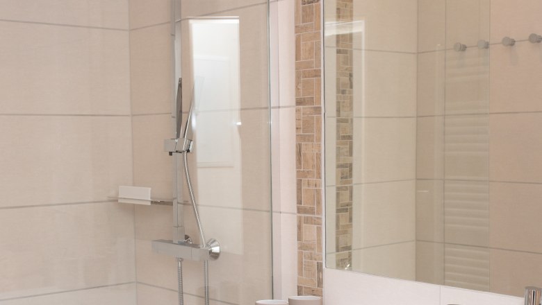 Badezimmer, © Familie Schwalm Modernes Badezimmer mit Dusche, Waschbecken und Handtüchern.