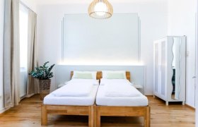 Gästezimmer, © Fam. Willmann Modernes Gästezimmer mit zwei Einzelbetten, einem Kleiderschrank und einer Pflanze.