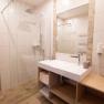Modernes Badezimmer mit Dusche, Waschbecken und Handt&uuml;chern.