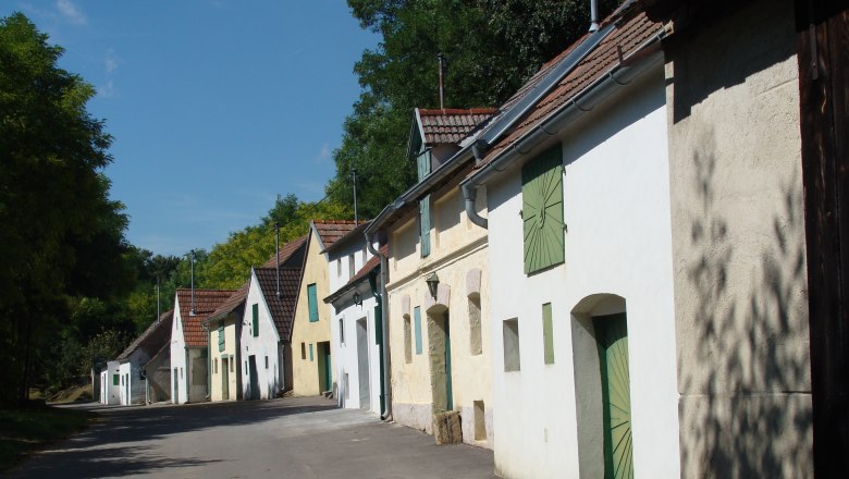 Reihe von Weinkellern in der Kellergasse Altlichtenwarth bei sonnigem Wetter.