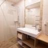 Modernes Badezimmer mit Dusche, Waschbecken und Handt&uuml;chern.