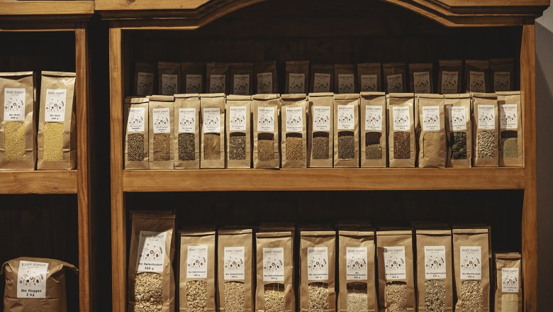 Regal mit verschiedenen Getreide- und Samenpackungen in einem Geschäft.