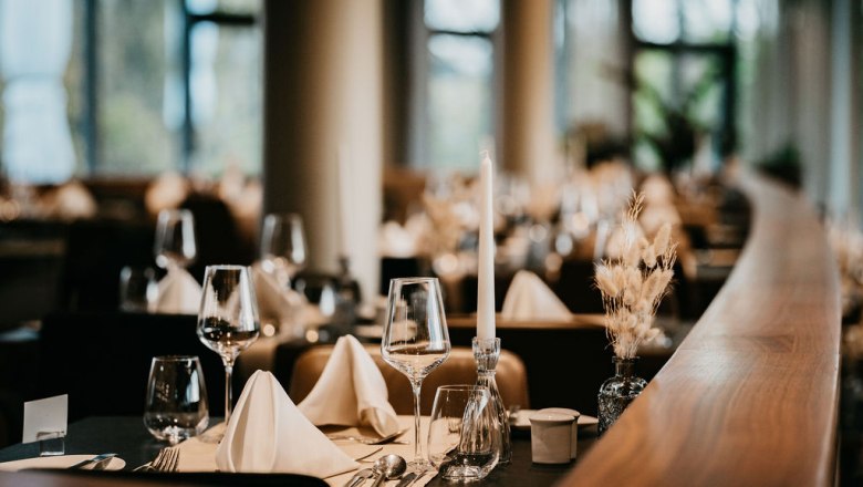 Elegantes Restaurant mit gedecktem Tisch, Weingläsern und Kerzen.