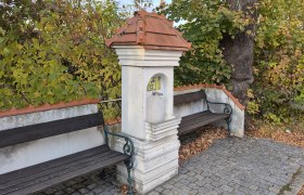 Zwei B&auml;nke an einem kleinen Brunnen in einem herbstlichen Park.