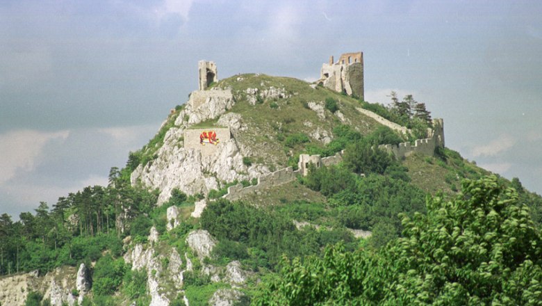 Ruinen der Burgruine Staatz auf einem H&uuml;gel mit gr&uuml;ner Vegetation.