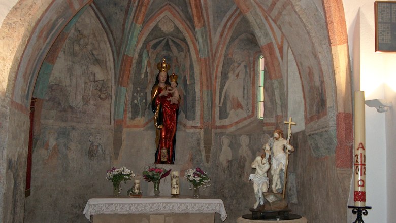 Innenansicht einer Kapelle mit Wandmalereien und religi&ouml;sen Statuen.