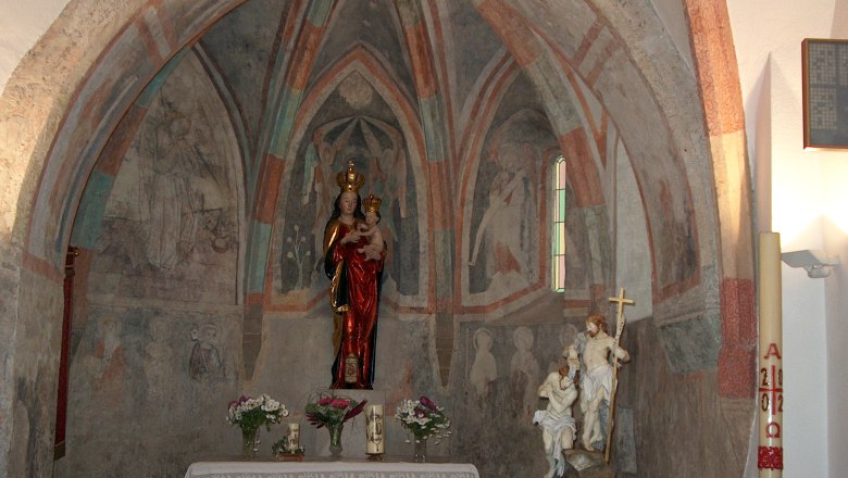 Innenansicht einer Kapelle mit Fresken und Statuen.