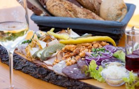 Heurigenplatte mit Aufschnitt, Zwiebeln, Gurken und Brot.